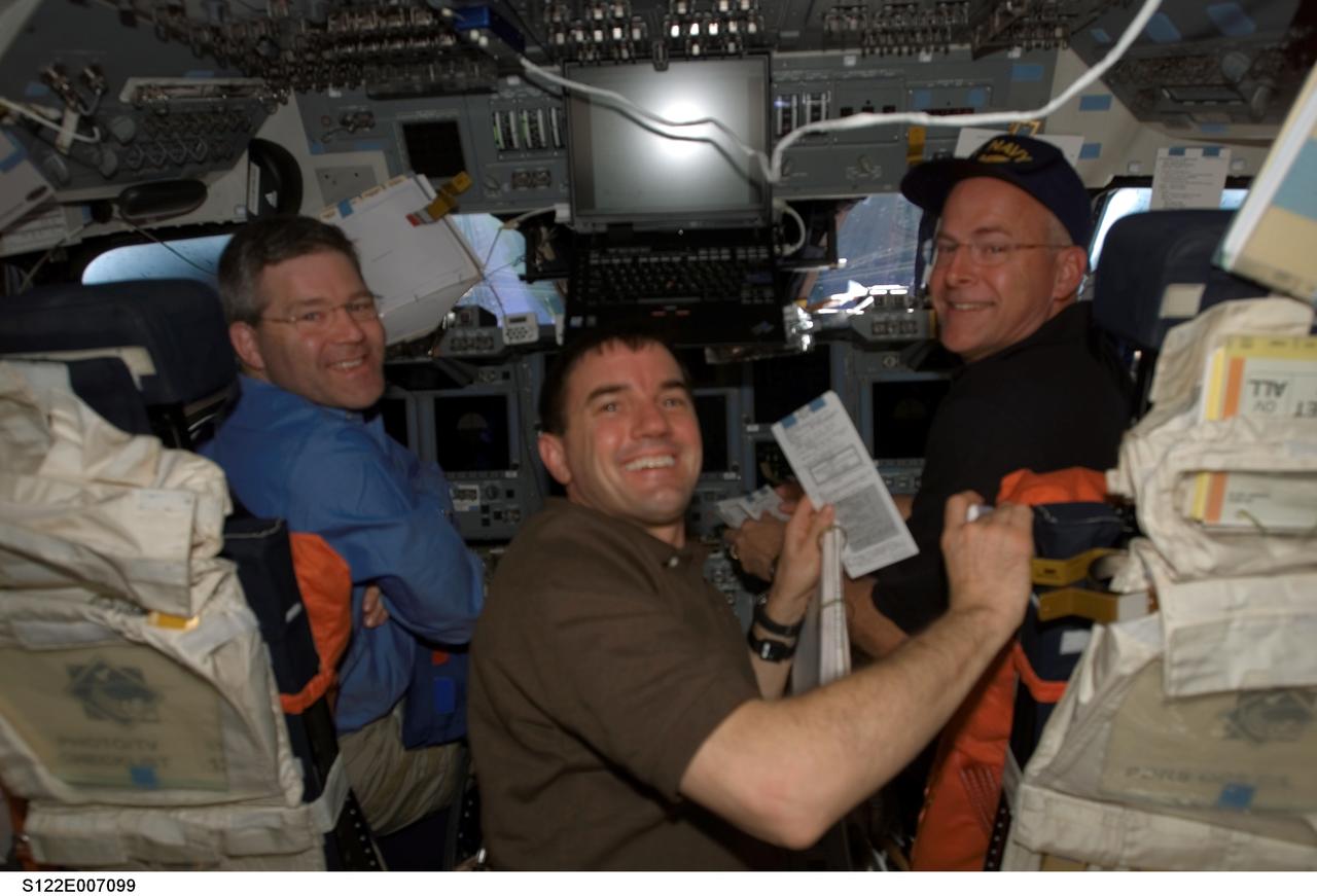 S122-E-007099 (9 Feb. 2008) --- Astronauts Steve Frick (left), STS-122 commander; Rex Walheim, mission specialist; and Alan Poindexter, pilot, take a moment for a photo on the flight deck of Space Shuttle Atlantis during flight day three activities.