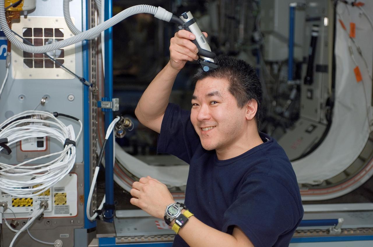 S122-E-007645 (10 Feb. 2008) --- Astronaut Daniel Tani, Expedition 16 flight engineer, trims his hair in the Harmony node of the International Space Station while Space Shuttle Atlantis is docked with the station. Tani used hair clippers fashioned with a vacuum device to garner freshly cut hair.