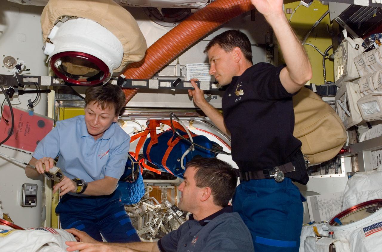 S122-E-007664 (10 Feb. 2008) --- Astronauts Peggy Whitson, Expedition 16 commander; Stanley Love and Rex Walheim (bottom), both STS-122 mission specialists, work in the Quest Airlock of the International Space Station while Space Shuttle Atlantis is docked with the station.