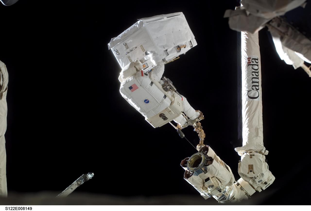 S122-E-008149 (13 Feb. 2008) --- Anchored to a foot restraint on the station's robotic Canadarm2, astronaut Rex Walheim, STS-122 mission specialist, transfers a large nitrogen tank assembly -- used for pressurizing the station's ammonia cooling system -- during the second scheduled session of extravehicular activity (EVA) as construction and maintenance continue on the International Space Station.