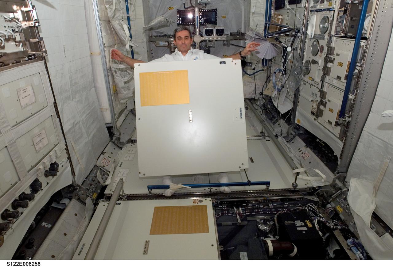 S122-E-008258 (13 Feb. 2008) --- European Space Agency (ESA) astronaut Leopold Eyharts, Expedition 16 flight engineer, holds a panel in the newly attached Columbus laboratory of the International Space Station while Space Shuttle Atlantis (STS-122) is docked with the station. The panel bears the names of European engineers who built Columbus.