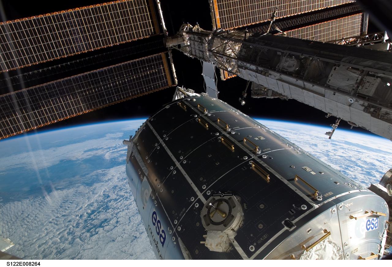 S122-E-008264 (13 Feb. 2008) --- Backdropped by the blackness of space and Earth's horizon, the Columbus laboratory (center) -- the newest addition to the International Space Station -- is featured in this image photographed by a crewmember on the Space Shuttle Atlantis while docked with the station.