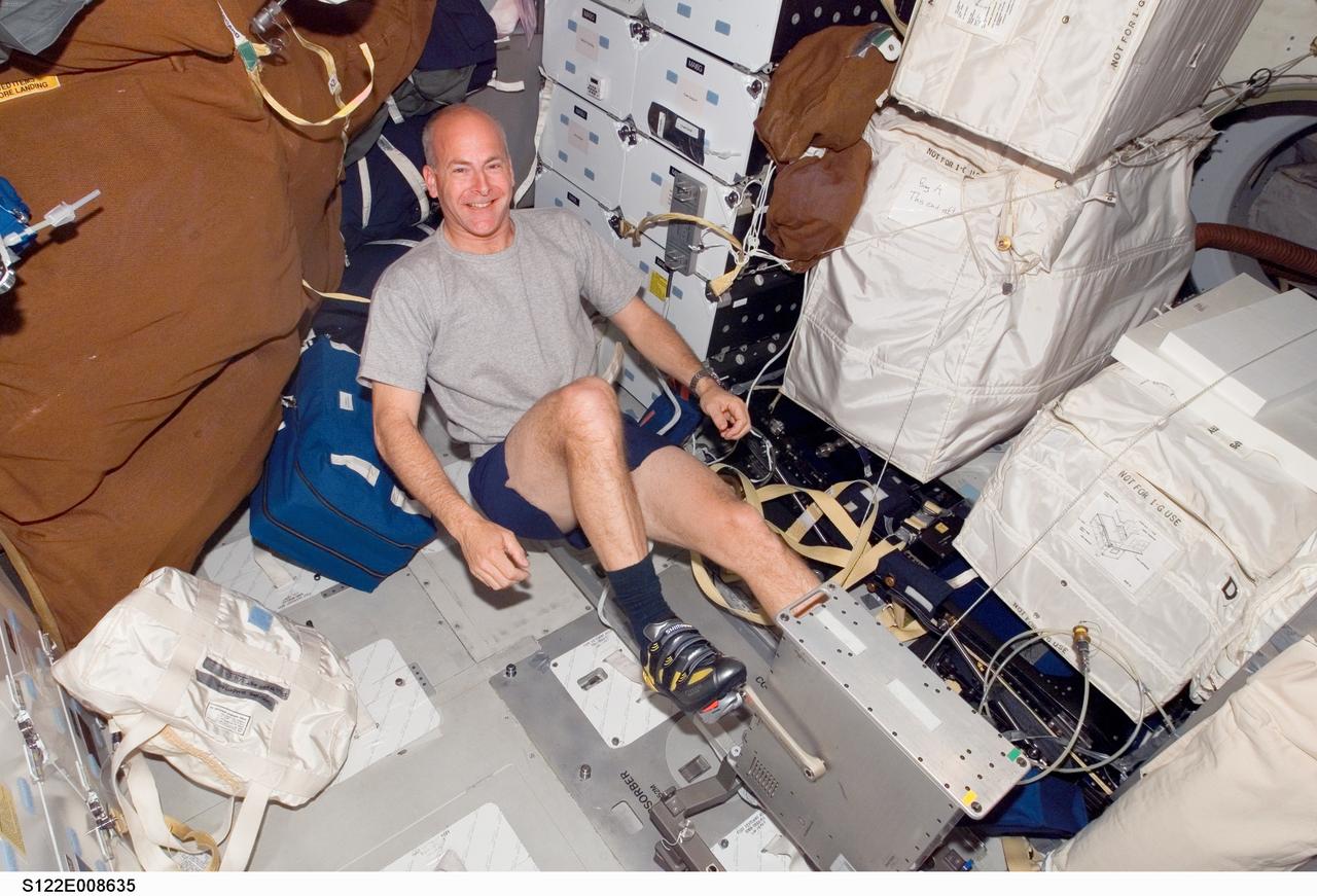 STS-122 Pilot Alan Poindexter exercises on the Cycle Ergometer on the Middeck (MDK) of the orbiter Atlantis. Photo was taken during Expedition 16/STS-122 joint operations.