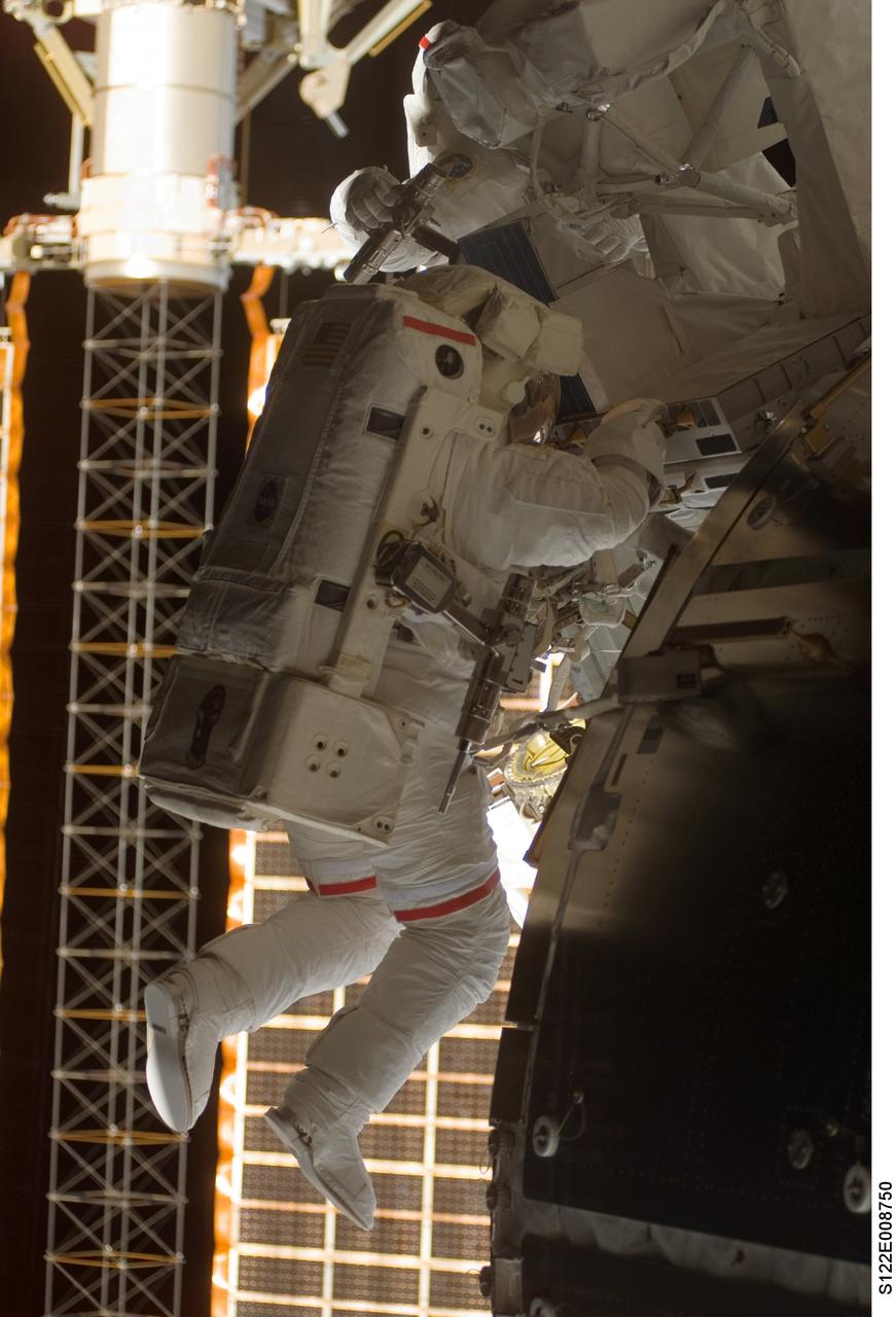 S122-E-008750 (15 Feb. 2008) --- Astronaut Rex Walheim (foreground), mission specialist, shares a spacewalk task with astronaut Stanley Love (partially obscured at top of frame), mission specialist. The two astronauts had paired up for the first of three scheduled STS-122 sessions of extravehicular activity earlier in the week and came back out for this final EVA on Feb. 15.