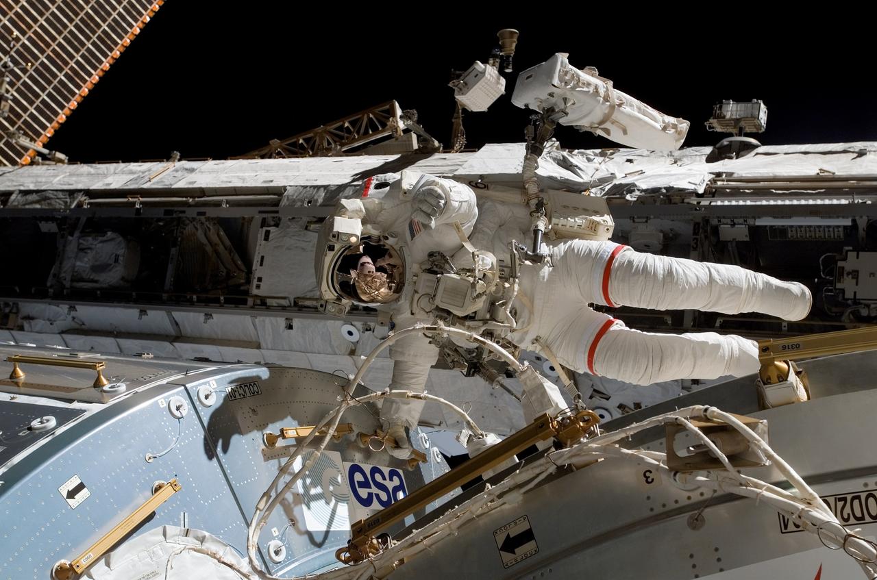 S122-E-008913 (15 Feb. 2008) --- Astronaut Rex Walheim, STS-122 mission specialist, holds onto a handrail on the Columbus laboratory, the newest piece of hardware on the International Space Station. In his helmet visor is mirrored the forward section of the Space Shuttle Atlantis, to which the station is docked. Astronaut Stanley Love (out of frame), mission specialist, shared this final period of STS-122 extravehicular activity (EVA) with Walheim.