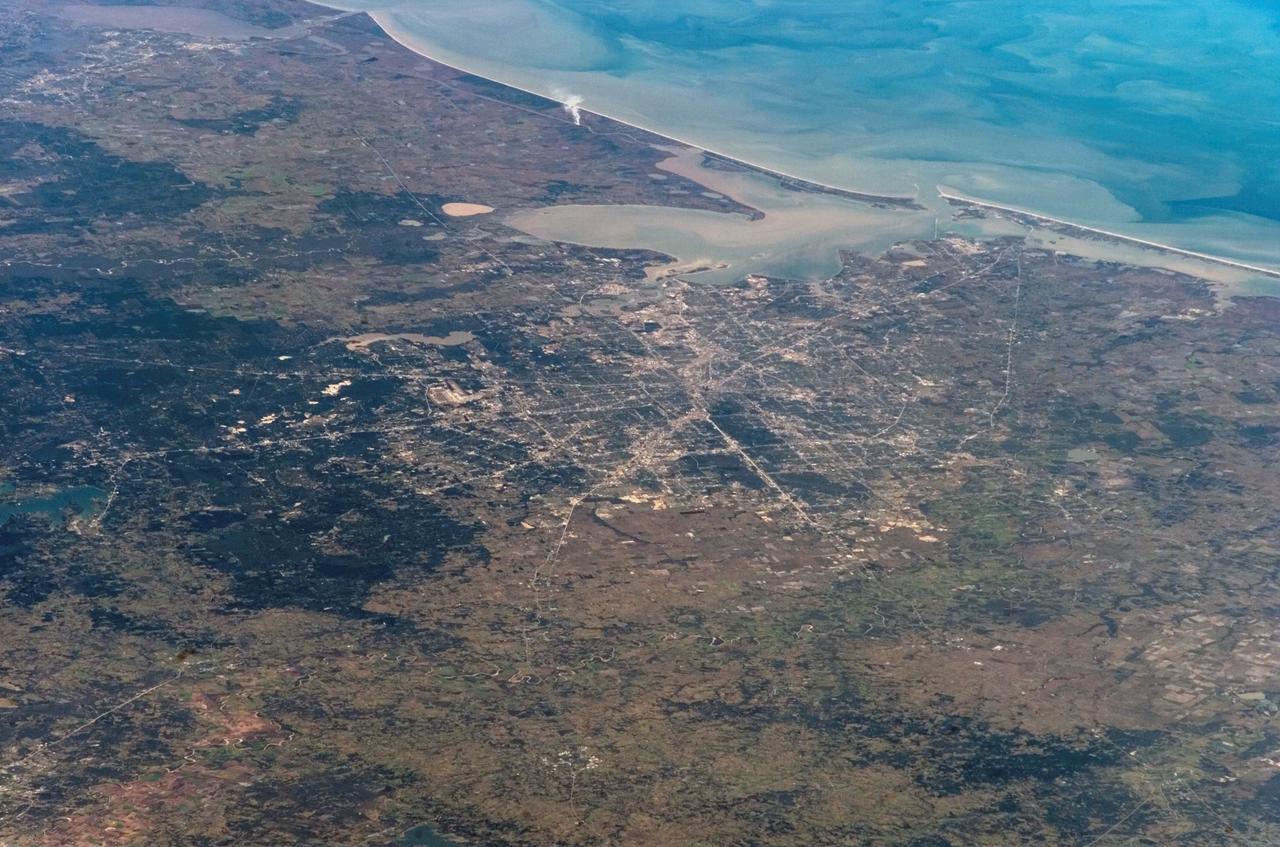 S122-E-009760 (17 Feb. 2008) --- This digital still, photographed from the Space Shuttle Atlantis, provides a view toward the southeast from a point northwest of the Greater Houston area, extending to Sabine Pass and the Louisiana/Texas border in the upper left corner and the Gulf of Mexico at top center and right. Portions of at least seven of Harris County's neighboring counties are visible in the broad view. Houston's "downtown" business district is just to the right of center in the frame, with the NASA-Johnson Space Center appearing approximately 25 miles from downtown to the southeast near the easily spotted Galveston Bay.