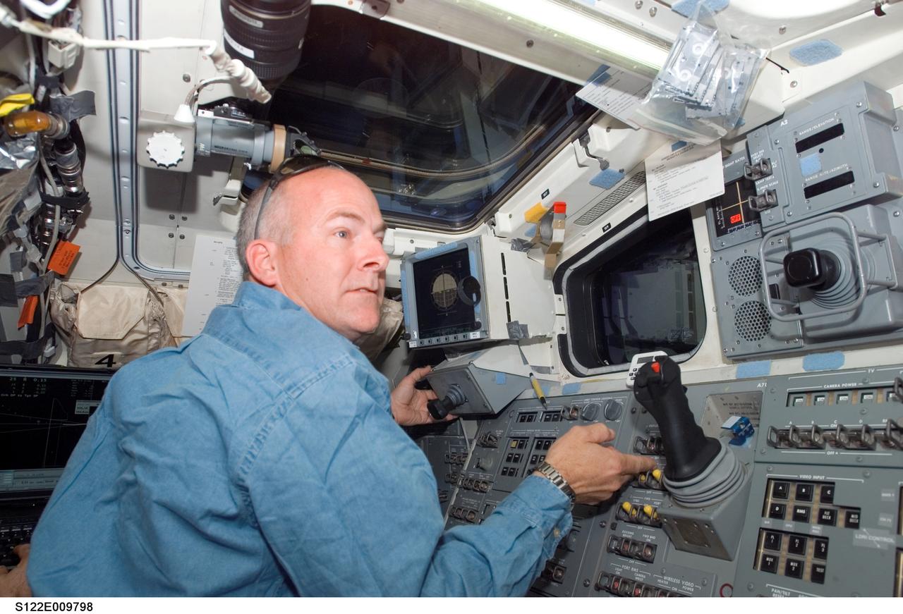 S122-E-009798 (18 Feb. 2008) --- Astronaut Alan Poindexter, STS-122 pilot, works the controls on the aft flight deck of Space Shuttle Atlantis during flight day 12 activities.