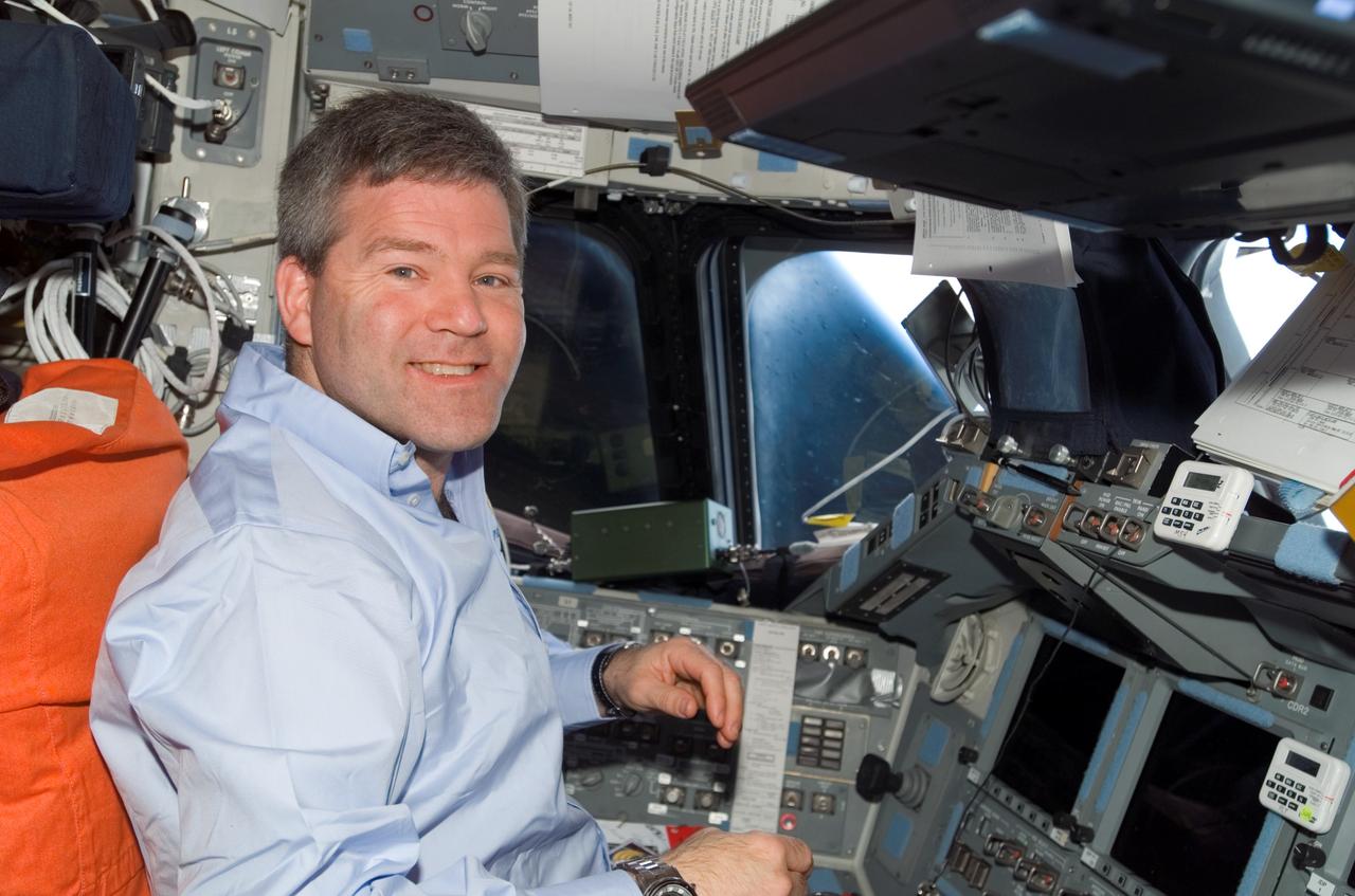 S122-E-010925 (18 Feb. 2008) --- Astronaut Steve Frick, STS-122 commander, smiles for a photo while monitoring data at the commander's station on the flight deck of Space Shuttle Atlantis during flight day 12 activities.
