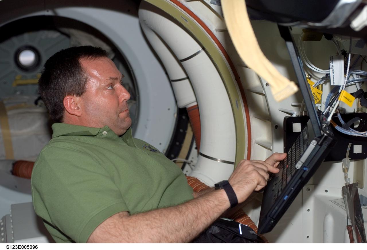 S123-E-005096 (11 March 2008) --- Astronaut Mike Foreman, STS-123 mission specialist, uses a computer on the middeck of Space Shuttle Endeavour late in flight day one activities.