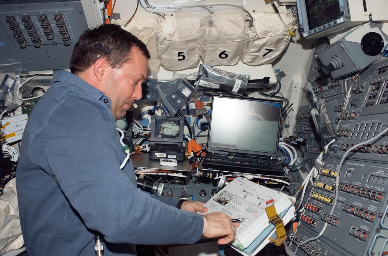 S123-E-005950 (14 March 2008) --- Astronaut Mike Foreman, STS-123 mission specialist, looks over a checklist on the aft flight deck of Space Shuttle Endeavour while docked with the International Space Station.