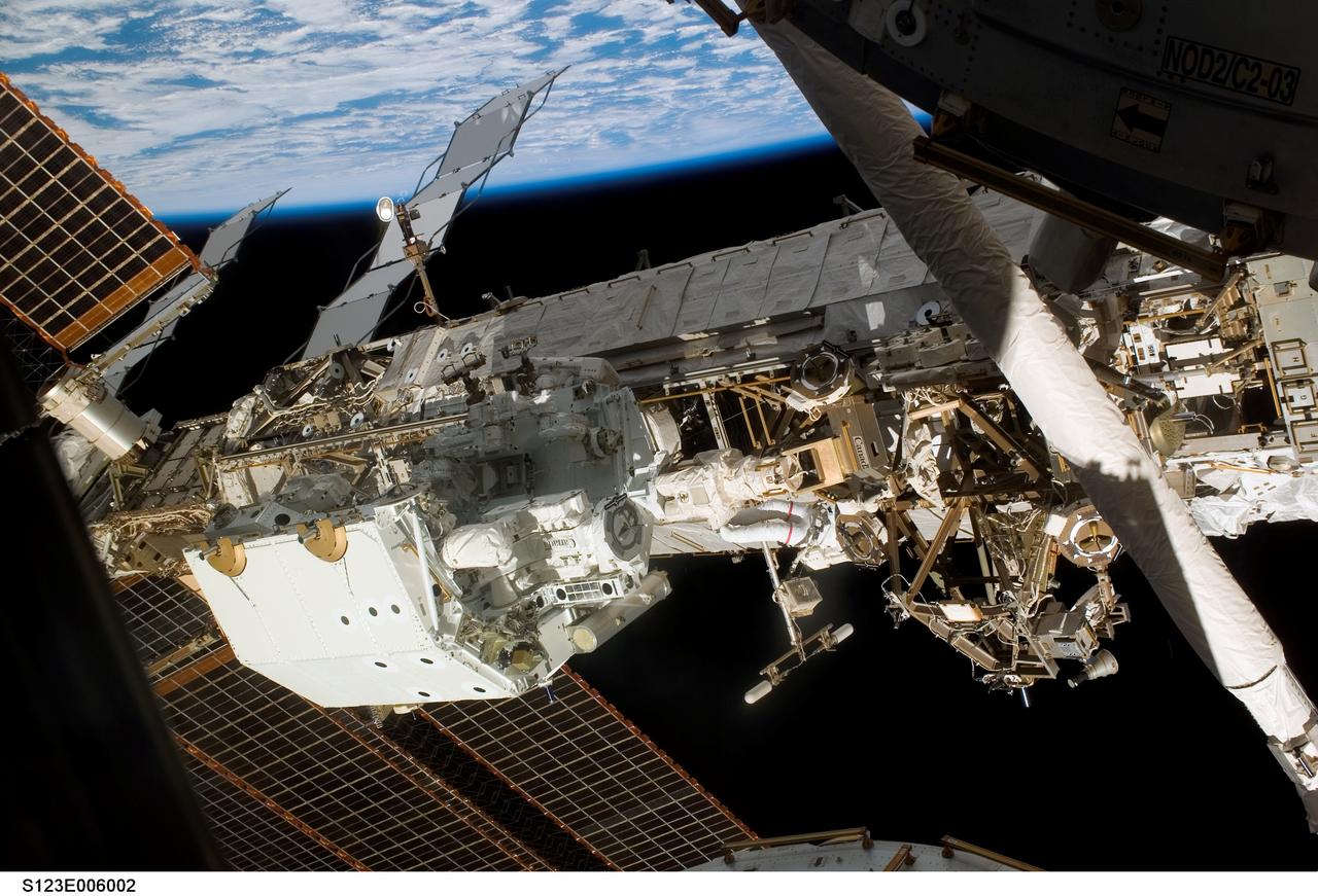 S123-E-006002 (13/14 March 2008) --- Astronaut Rick Linnehan (center), STS-123 mission specialist, participates in the mission's first scheduled session of extravehicular activity (EVA) as construction and maintenance continue on the International Space Station. During the seven-hour and one-minute spacewalk, Linnehan and astronaut Garrett Reisman (out of frame), Expedition 16 flight engineer, prepared the Japanese logistics module-pressurized section (JLP) for removal from Space Shuttle Endeavour's payload bay; opened the Centerline Berthing Camera System on top of the Harmony module; removed the Passive Common Berthing Mechanism and installed both the Orbital Replacement Unit (ORU) tool change out mechanisms on the Canadian-built Dextre robotic system (center left), the final element of the station's Mobile Servicing System.