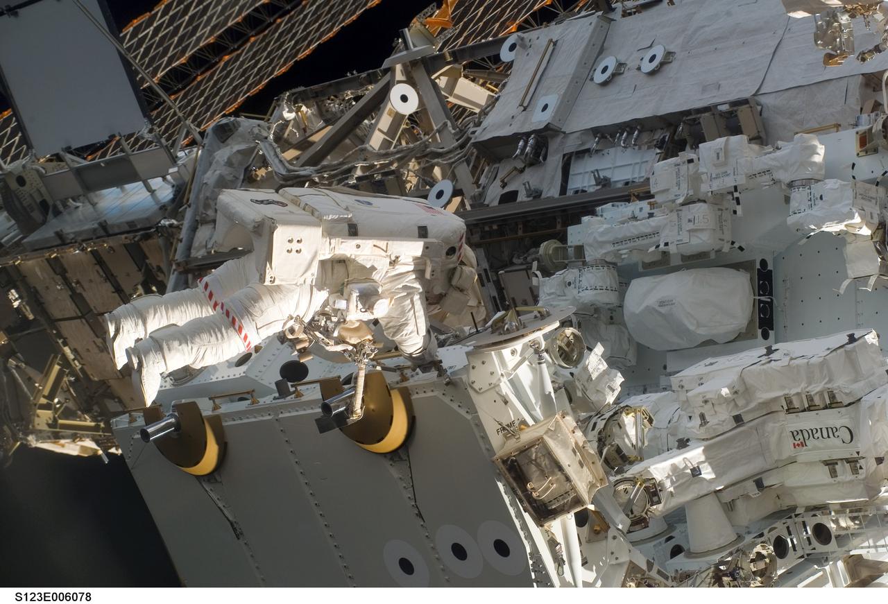 S123-E-006078 (13/14 March 2008) --- Astronaut Garrett Reisman, Expedition 16 flight engineer, participates in the mission's first scheduled session of extravehicular activity (EVA) as construction and maintenance continue on the International Space Station. During the seven-hour and one-minute spacewalk, Reisman and astronaut Rick Linnehan (out of frame), STS-123 mission specialist, prepared the Japanese logistics module-pressurized section (JLP) for removal from Space Shuttle Endeavour's payload bay; opened the Centerline Berthing Camera System on top of the Harmony module; removed the Passive Common Berthing Mechanism and installed both the Orbital Replacement Unit (ORU) tool change out mechanisms on the Canadian-built Dextre robotic system, the final element of the station's Mobile Servicing System.