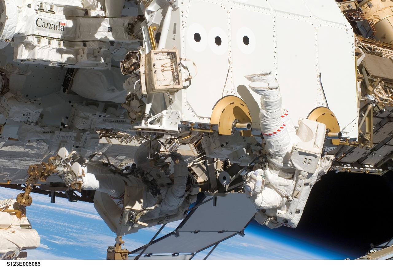 S123-E-006086 (13/14 March 2008) --- Astronauts Rick Linnehan (left), STS-123 mission specialist; and Garrett Reisman, Expedition 16 flight engineer, participate in the mission's first scheduled session of extravehicular activity (EVA) as construction and maintenance continue on the International Space Station. During the seven-hour and one-minute spacewalk, Linnehan and Reisman prepared the Japanese logistics module-pressurized section (JLP) for removal from Space Shuttle Endeavour's payload bay; opened the Centerline Berthing Camera System on top of the Harmony module; removed the Passive Common Berthing Mechanism and installed both the Orbital Replacement Unit (ORU) tool change out mechanisms on the Canadian-built Dextre robotic system, the final element of the station's Mobile Servicing System.