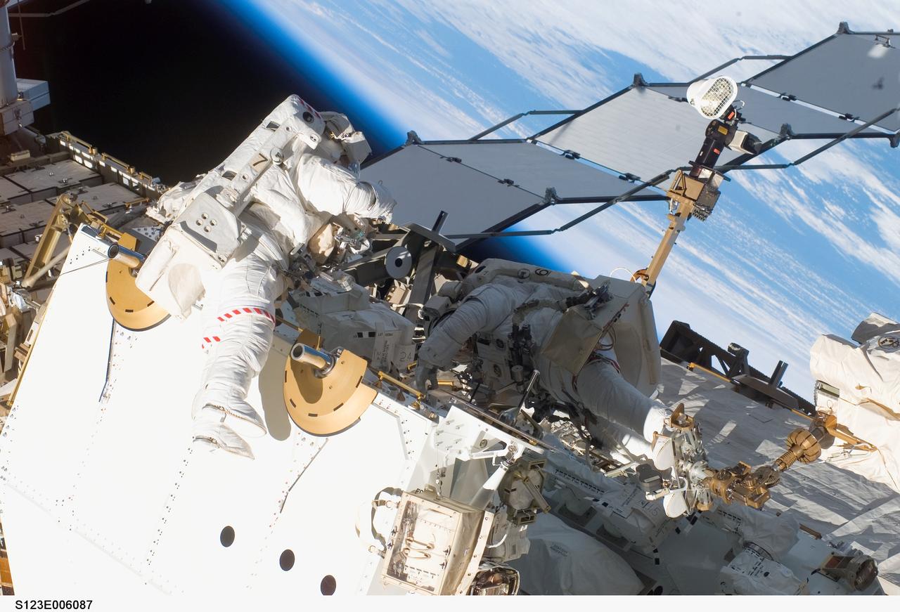 S123-E-006087 (13/14 March 2008) --- Astronauts Rick Linnehan (right), STS-123 mission specialist; and Garrett Reisman, Expedition 16 flight engineer, participate in the mission's first scheduled session of extravehicular activity (EVA) as construction and maintenance continue on the International Space Station. During the seven-hour and one-minute spacewalk, Linnehan and Reisman prepared the Japanese logistics module-pressurized section (JLP) for removal from Space Shuttle Endeavour's payload bay; opened the Centerline Berthing Camera System on top of the Harmony module; removed the Passive Common Berthing Mechanism and installed both the Orbital Replacement Unit (ORU) tool change out mechanisms on the Canadian-built Dextre robotic system, the final element of the station's Mobile Servicing System.