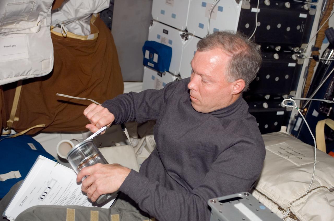 S123-E-006327 (15 March 2008) --- Astronaut Dominic Gorie, STS-123 commander, manually activates a Group Activation Pack (GAP) using a small hand crank on the middeck of Space Shuttle Endeavour while docked with the International Space Station. This will introduce fresh growth medium into the cultures. The GAP contains eight Fluid Processing Apparatus (FPA) tubes.
