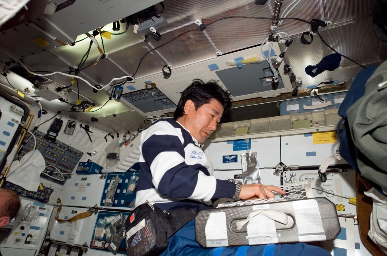 S123-E-006371 (15 March 2008) --- Japan Aerospace Exploration Agency (JAXA) astronaut Takao Doi, STS-123 mission specialist, prepares to eat a meal at the galley on the middeck of Space Shuttle Endeavour while docked with the International Space Station.
