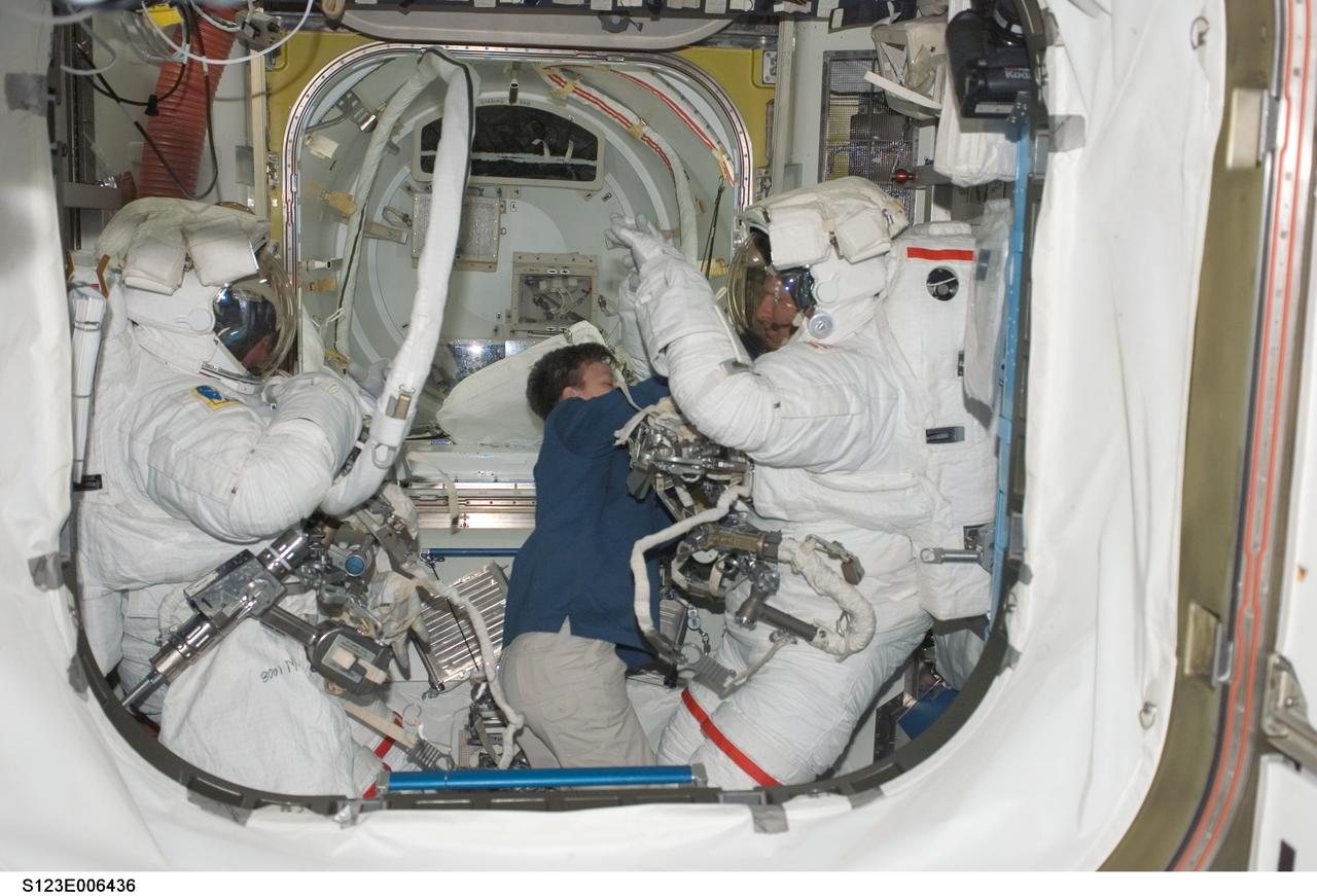 S123-E-006436 (16 March 2008) --- Attired in their Extravehicular Mobility Unit (EMU) spacesuits, astronauts Mike Foreman (left) and Rick Linnehan, both STS-123 mission specialists, are pictured in the Quest Airlock of the International Space Station as the mission's second session of extravehicular activity (EVA) draws to a close. Astronaut Peggy Whitson, Expedition 16 commander, assisted Foreman and Linnehan in the doffing of the spacesuits.