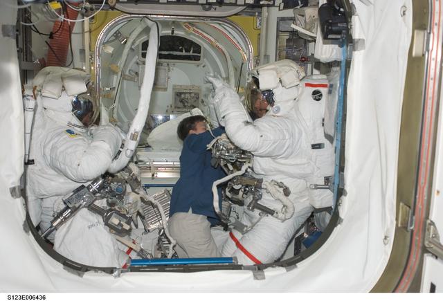 NASA image: Whitson assists Foreman and Linnehan with their EMUs in the A/L during Joint Operations