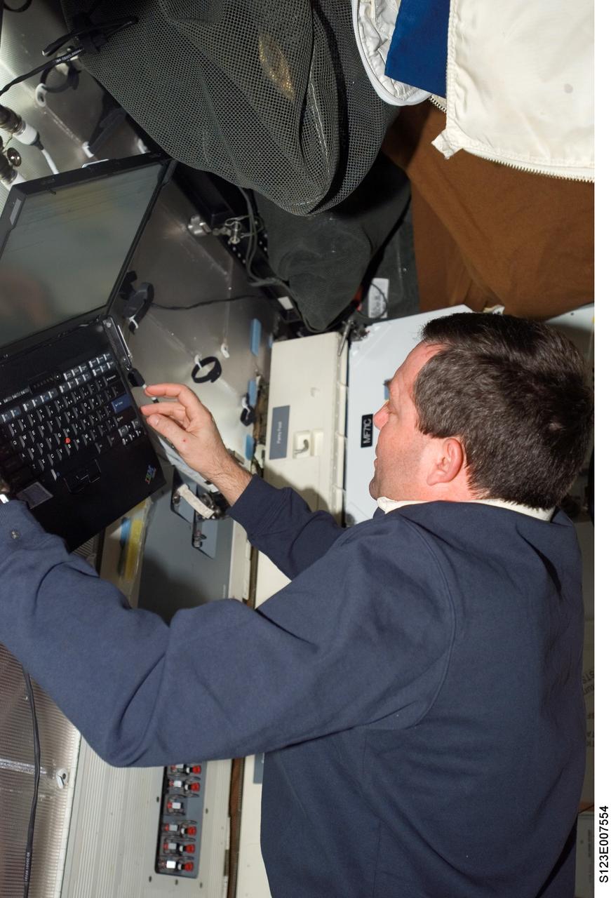 S123-E-007554 (19 March 2008) --- NASA astronaut Mike Foreman, STS-123 mission specialist, uses a computer on the middeck of Space Shuttle Endeavour while docked with the International Space Station.
