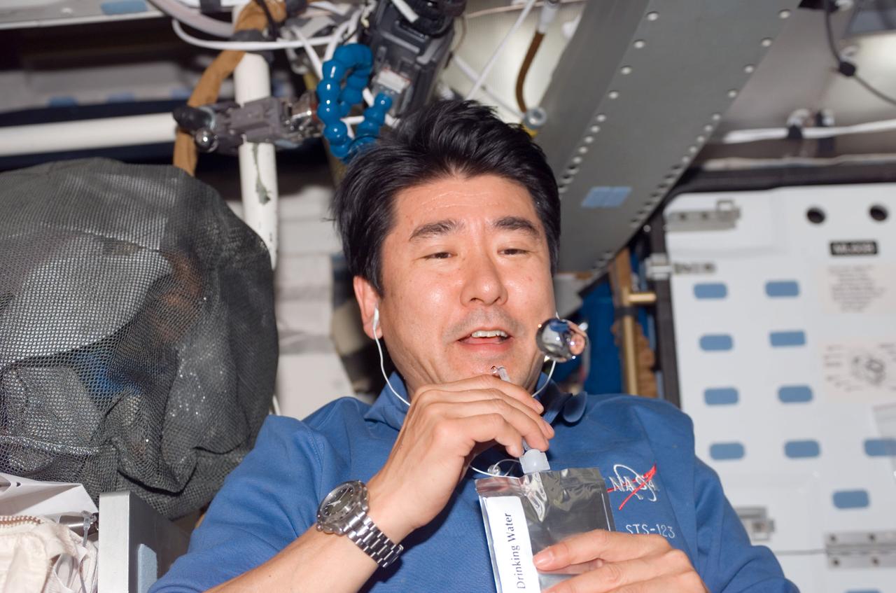 S123-E-007674 (19 March 2008) --- Japan Aerospace Exploration Agency (JAXA) astronaut Takao Doi, STS-123 mission specialist, watches a bubble float freely, after having squeezed it from his beverage container, on the middeck of Space Shuttle Endeavour while docked with the International Space Station.