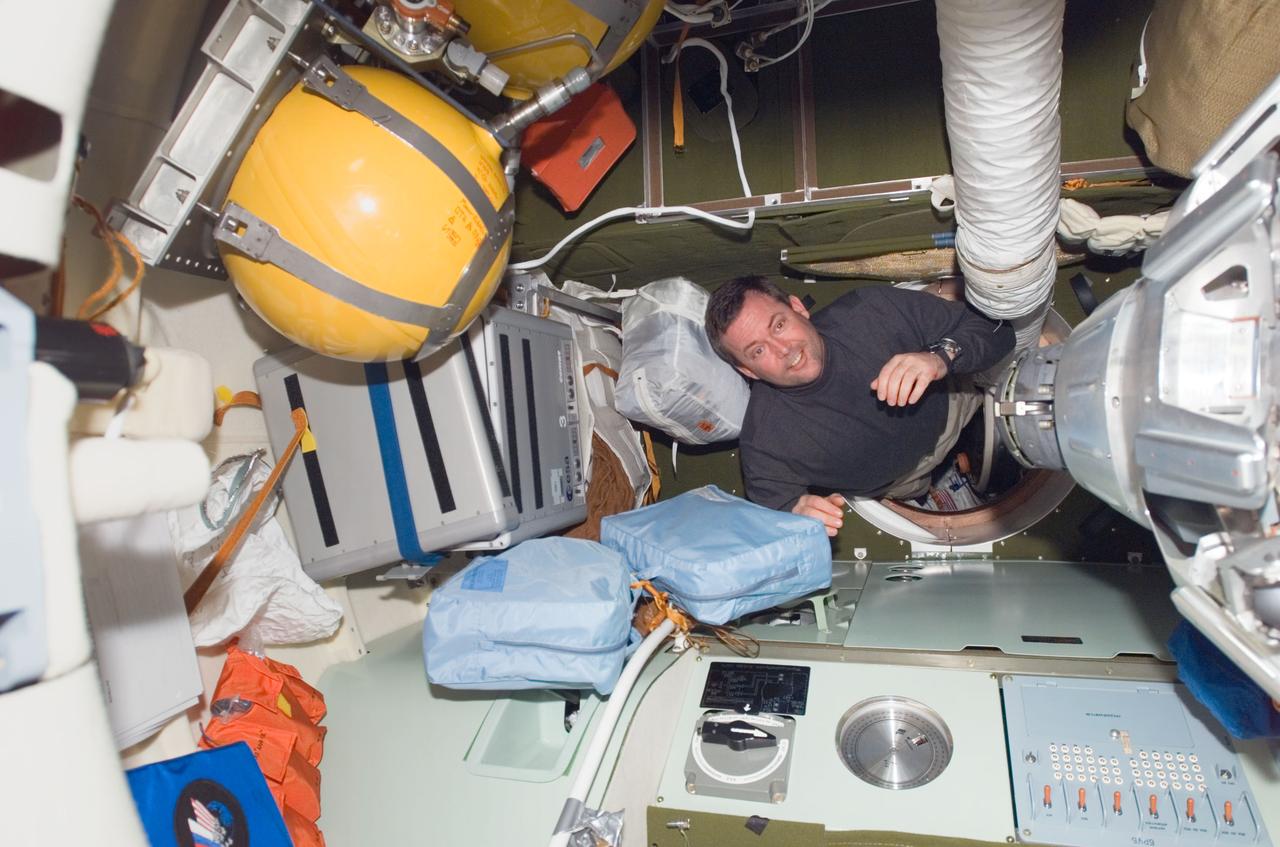 S123-E-008683 (23 March 2008) --- Astronaut Mike Foreman, STS-123 mission specialist, moves through a hatch in the Pirs Docking Compartment of the International Space Station while Space Shuttle Endeavour is docked with the station.
