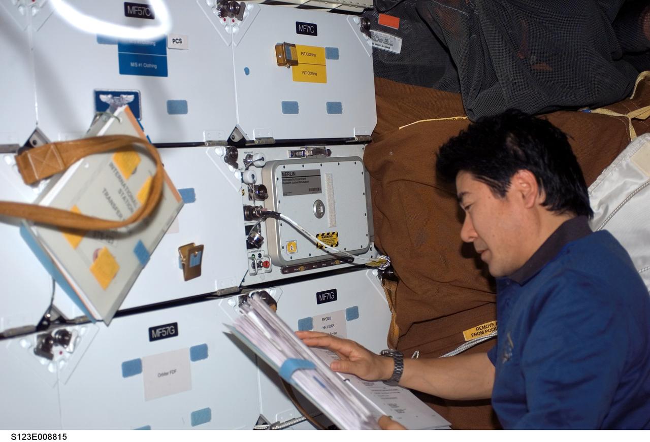 S123-E-008815 (23 March 2008) --- Japan Aerospace Exploration Agency (JAXA) astronaut Takao Doi, STS-123 mission specialist, looks over a checklist on the middeck of Space Shuttle Endeavour while docked with the International Space Station.