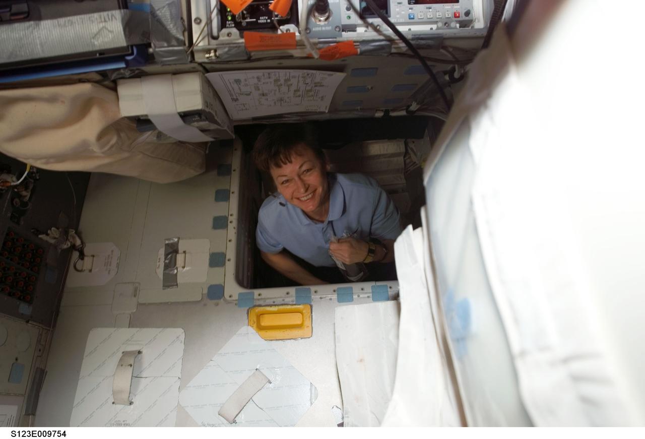 S123-E-009754 (24 March 2008) --- Astronaut Peggy Whitson, Expedition 16 commander, smiles for the camera while in the hatch which connects the flight deck and middeck of Space Shuttle Endeavour while docked with the International Space Station.