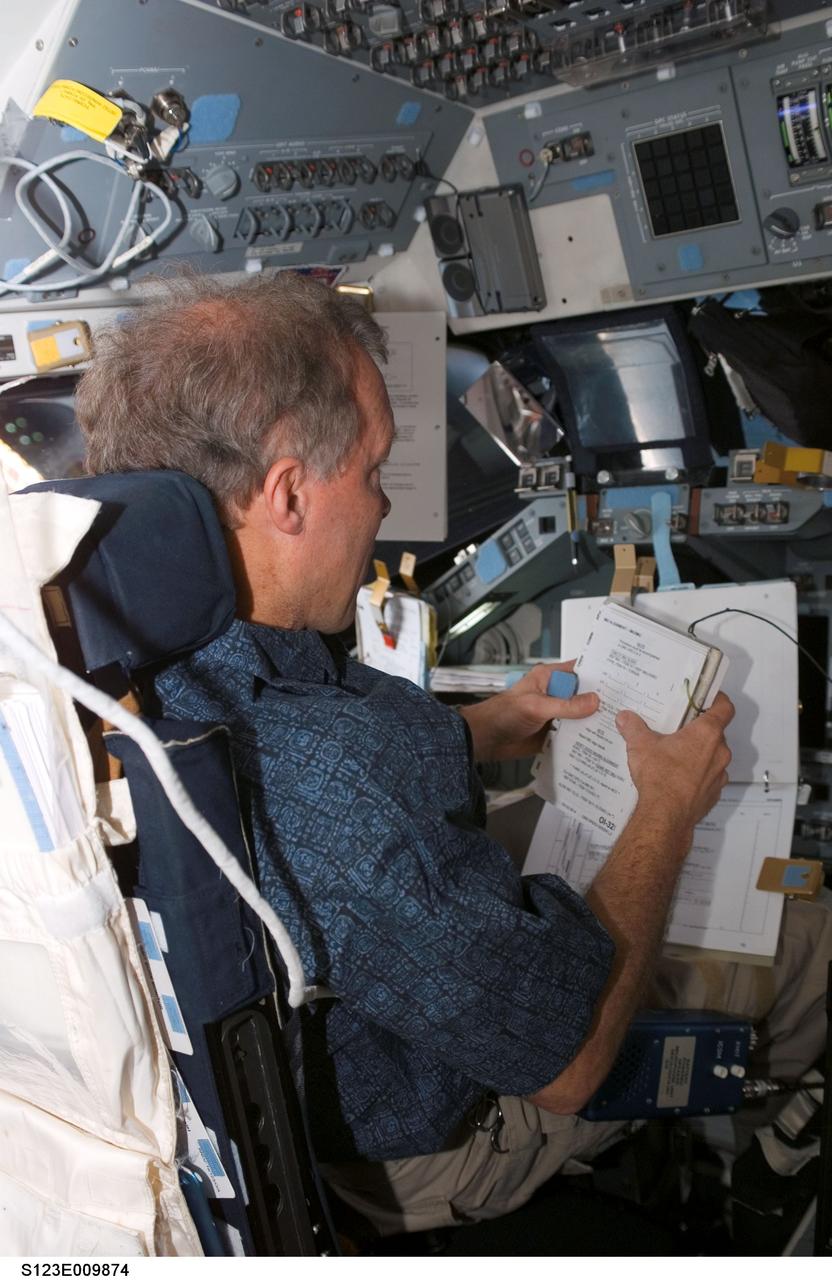 S123-E-009874 (24 March 2008) --- Astronaut Dominic Gorie, STS-123 commander, looks over a checklist while occupying the commander's station on the flight deck of Space Shuttle Endeavour while docked with the International Space Station.