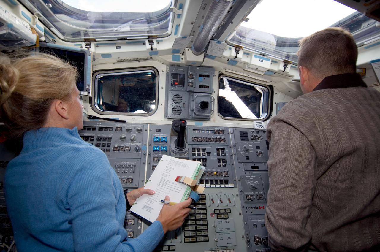 S124-E-005421 (1 June 2008) --- Astronauts Karen Nyberg, STS-124 mission specialist, and Ken Ham, pilot, work the controls on the aft flight deck of Space Shuttle Discovery during flight day two activities.