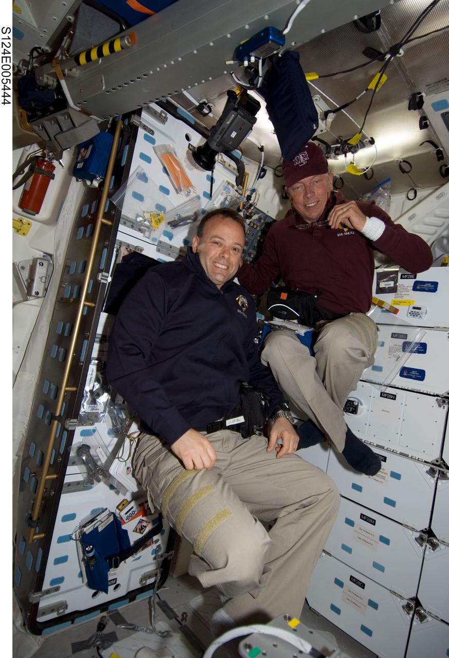 S124-E-005444 (1 June 2008) --- Astronauts Ron Garan (bottom) and Mike Fossum, both STS-124 mission specialists, are pictured near the galley on the middeck of Space Shuttle Discovery during flight day two activities.