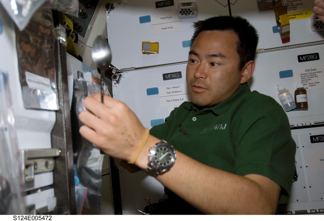 S124-E-005472 (1 June 2008) --- Japan Aerospace Exploration Agency (JAXA) astronaut Akihiko Hoshide, STS-124 mission specialist, prepares to eat a meal at the galley on the middeck of Space Shuttle Discovery.