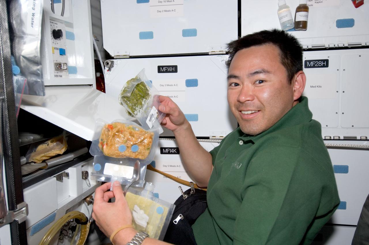 S124-E-005477 (1 June 2008) --- Japan Aerospace Exploration Agency (JAXA) astronaut Akihiko Hoshide, STS-124 mission specialist, prepares to eat a meal at the galley on the middeck of Space Shuttle Discovery.