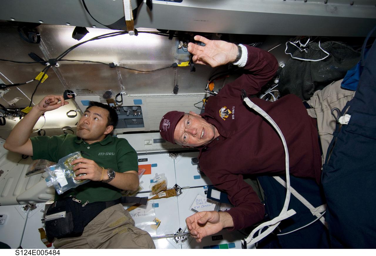S124-E-005484 (1 June 2008) --- Japan Aerospace Exploration Agency (JAXA) astronaut Akihiko Hoshide (left) and NASA astronaut Mike Fossum, both STS-124 mission specialists, are pictured on the middeck of Space Shuttle Discovery during flight day two activities.