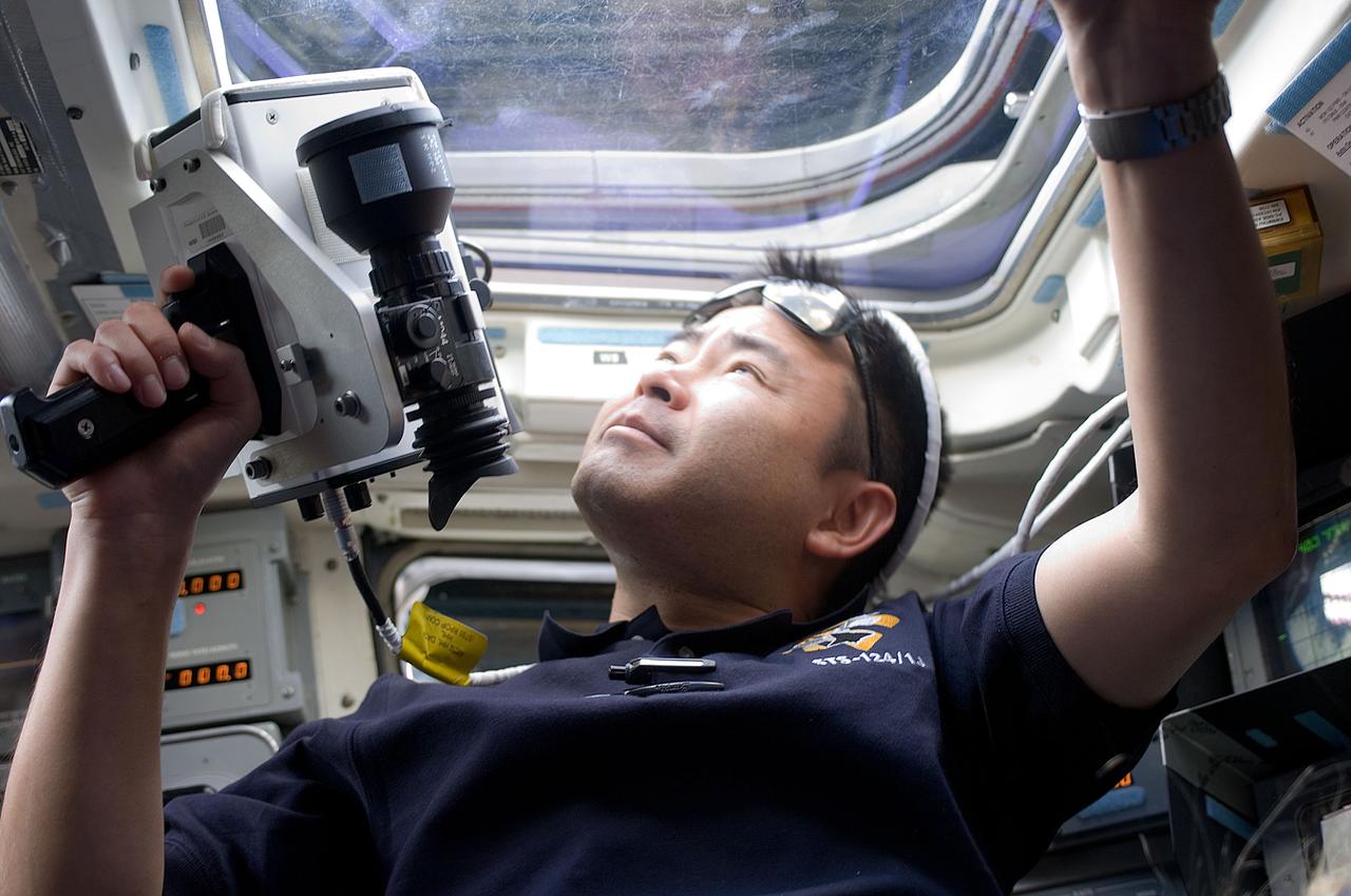 S124-E-005570 (2 June 2008) --- Japan Aerospace Exploration Agency (JAXA) astronaut Akihiko Hoshide, STS-124 mission specialist, uses a handheld laser ranging device on the aft flight deck of the Space Shuttle Discovery to track the range of the International Space Station during rendezvous operations.