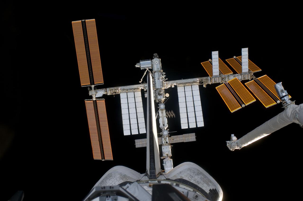 S124-E-005577 (2 June 2008) --- As seen through windows on the aft flight deck of Space Shuttle Discovery, the shuttle's robotic arm, vertical stabilizer, orbital maneuvering system (OMS) pods and the approaching International Space Station are featured in this image photographed by an STS-124 crewmember during rendezvous and docking activities. Docking occurred at 2:03 p.m. (EDT) on June 2, 2008.
