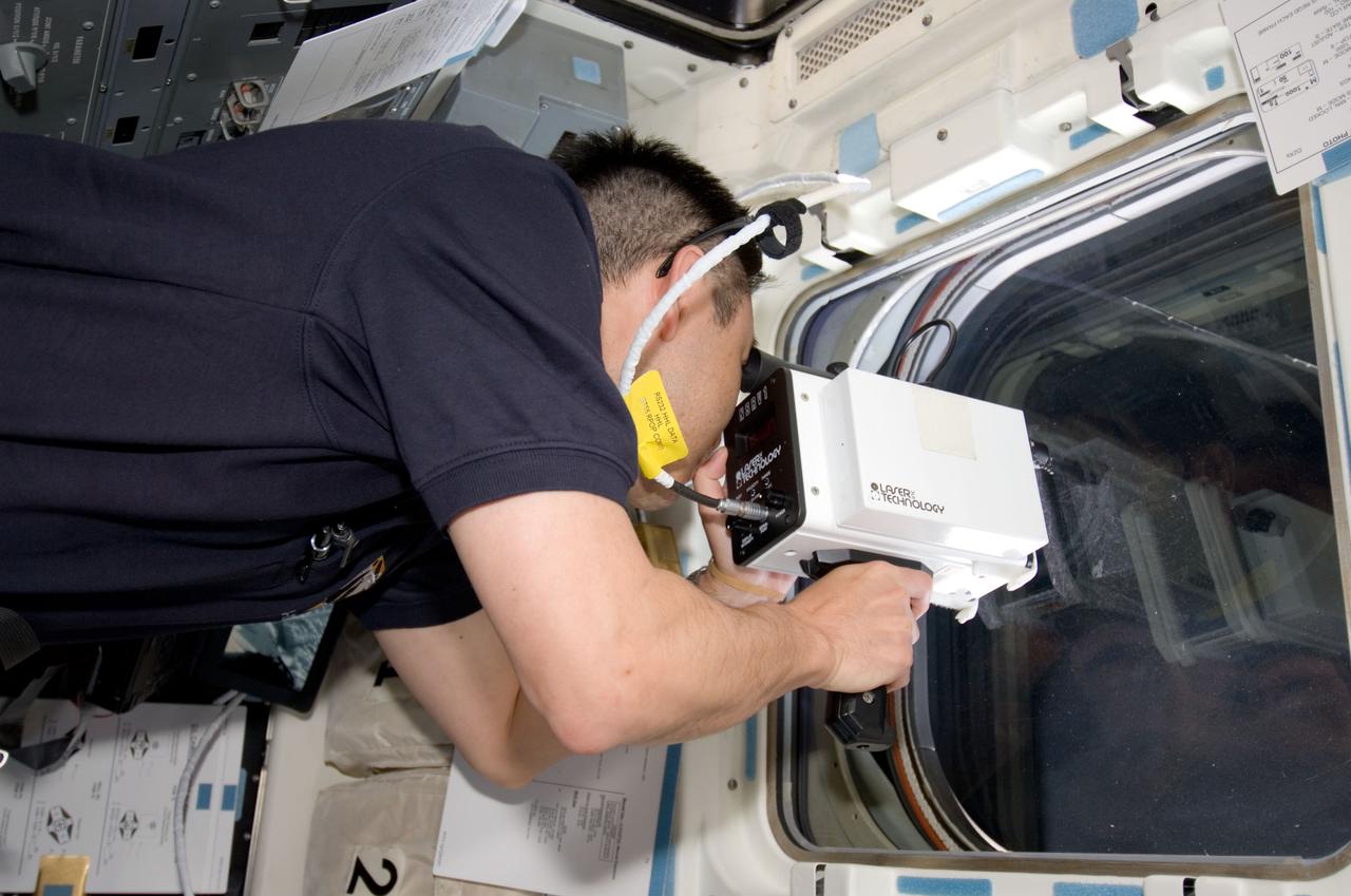 S124-E-005655 (2 June 2008) --- Japan Aerospace Exploration Agency (JAXA) astronaut Akihiko Hoshide, STS-124 mission specialist, uses a handheld laser ranging device on the aft flight deck of the Space Shuttle Discovery to track the range of the International Space Station during rendezvous operations.