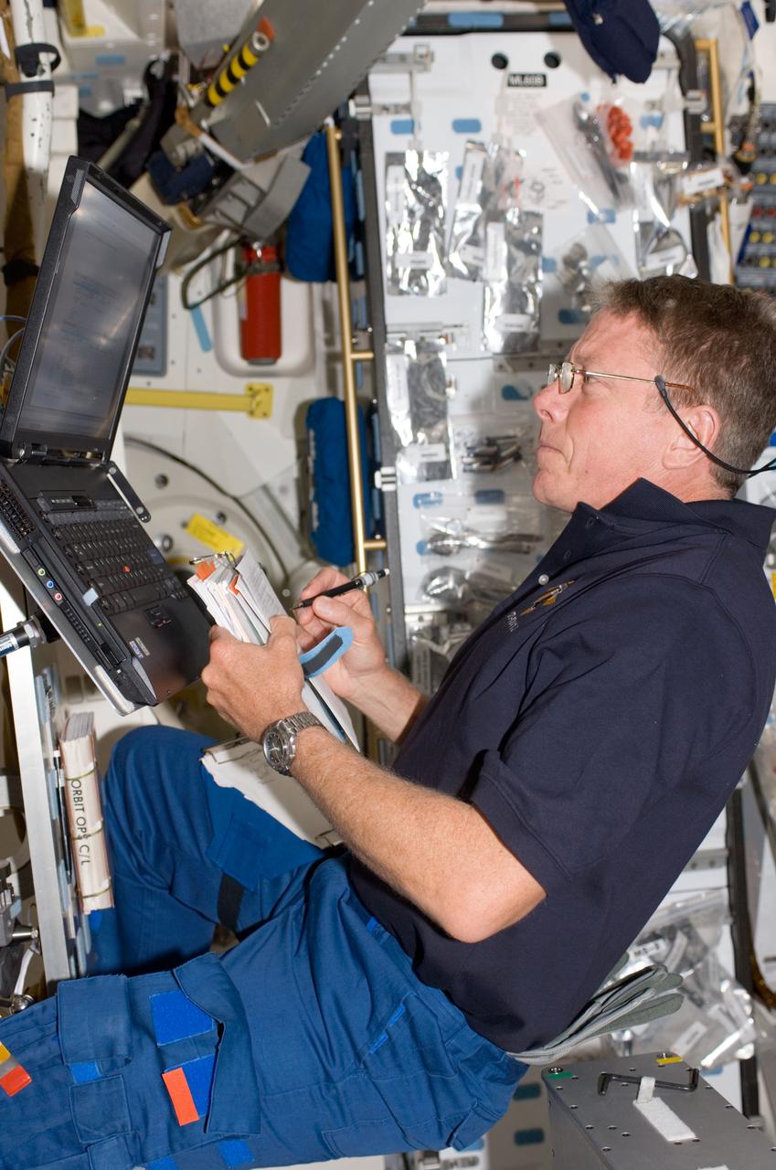 S124-E-006181 (4 June 2008) --- Astronaut Mike Fossum, STS-124 mission specialist, uses a computer on the middeck of Space Shuttle Discovery while docked with the International Space Station.