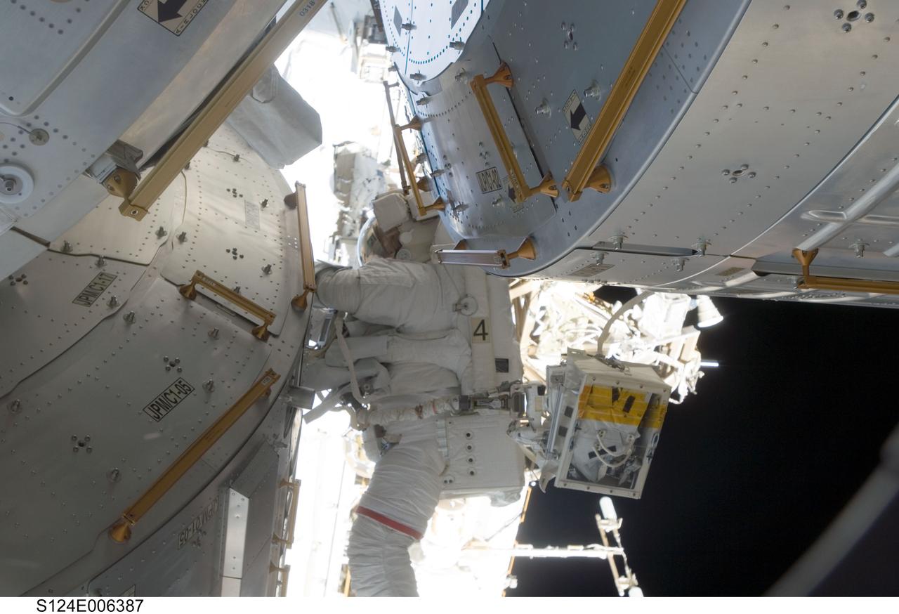 S124-E-006387 (5 June 2008) --- Astronaut Mike Fossum, STS-124 mission specialist, participates in the mission's second scheduled session of extravehicular activity (EVA) as construction and maintenance continue on the International Space Station. During the seven-hour, 11-minute spacewalk, Fossum and astronaut Ron Garan (out of frame), mission specialist, installed television cameras on the front and rear of the Kibo Japanese Pressurized Module (JPM) to assist Kibo robotic arm operations, removed thermal covers from the Kibo robotic arm, prepared an upper JPM docking port for flight day seven's attachment of the Kibo logistics module, readied a spare nitrogen tank assembly for its installation during the third spacewalk, retrieved a failed television camera from the Port 1 truss, and inspected the port Solar Alpha Rotary Joint (SARJ).
