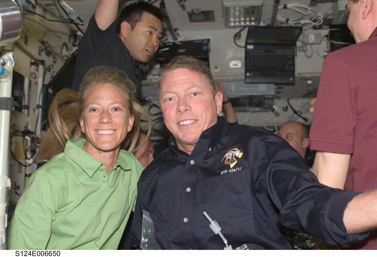 S124-E-06650 (6 June 2008) --- Astronauts Karen Nyberg and Mike Fossum, both STS-124 mission specialists,  share one of the few moments of leisure afforded to the Discovery and space station crewmembers aboard the International Space Station. In the background, from the left, are JAXA astronaut Akihiko Hoshide, along with astronaut Garrett Reisman (partially obscured), both mission specialists, and cosmonaut Sergei Volkov (partially out of frame), Expedition 17 commander.