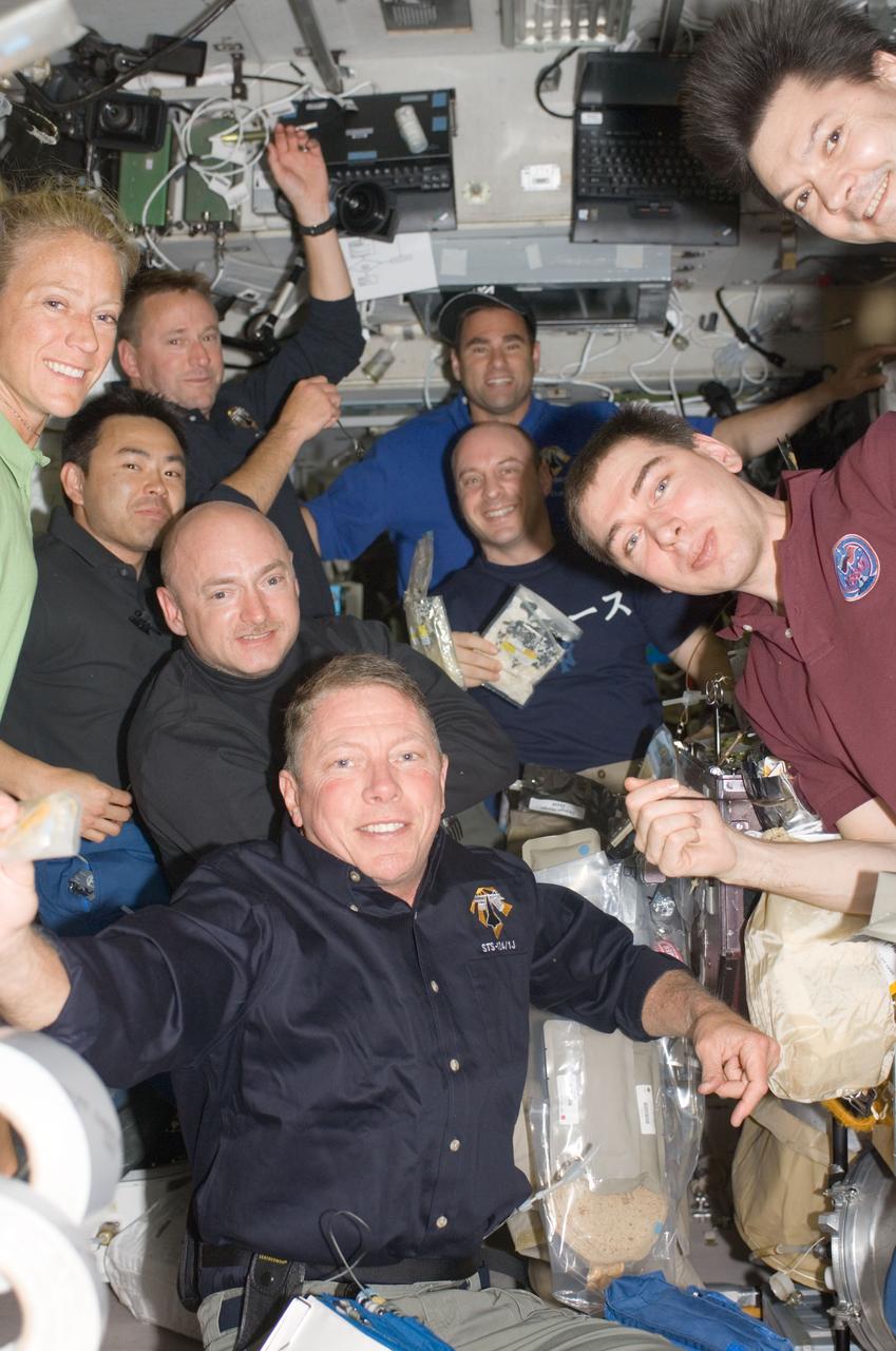 S124-E-006671 (6 June 2008) --- Nine of ten astronauts and cosmonauts currently sharing work on the International Space Station squeeze into an informal group portrait during mealtime on the Zvezda service module. Astronaut Mike Fossum, STS-124 mission specialist, is in center foreground. Pictured clockwise from his position are astronauts Mark Kelly, shuttle commander; Akihiko Hoshide, mission specialist; Karen Nyberg, mission specialist; Ken Ham, pilot; and Greg Chamitoff, Expedition 17 flight engineer; along with cosmonauts Oleg Kononenko, station flight engineer; and Sergei Volkov, station commander; and astronaut Garrett Reisman, STS-124 mission specialist. Not pictured is astronaut Ron Garan, STS-124 mission specialist.