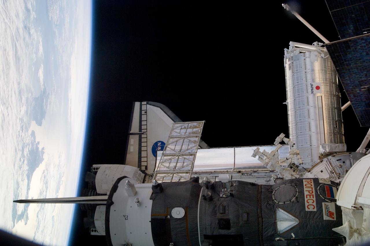 S124-E-006865 (6 June 2008) --- One of a series of digital still images documenting the Japanese Experiment Module, or JEM, also called Kibo, in its new home on the International Space Station, this view features Kibo's exterior, Earth's horizon and a couple of "visiting" spacecraft. The Space Shuttle Discovery and a Russian Progress resupply craft are seen near foreground.