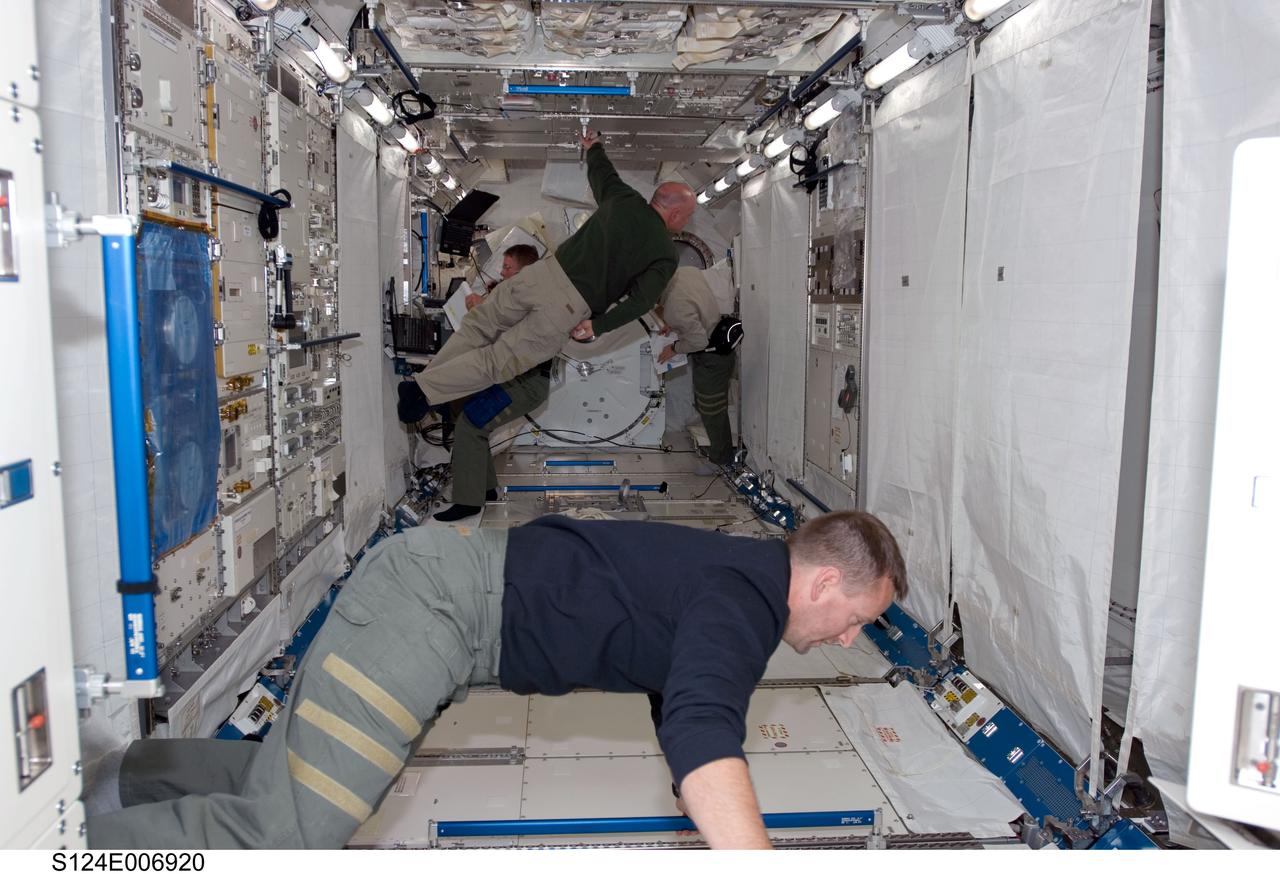 S124-E-006920 (6 June 2008) --- Astronauts Ken Ham (foreground), STS-124 pilot; Mark Kelly, commander; Mike Fossum (partially obscured, left) and Ron Garan (partially obscured, right), both mission specialists, work in the newly installed Kibo Japanese Pressurized Module while Space Shuttle Discovery is docked with the station.