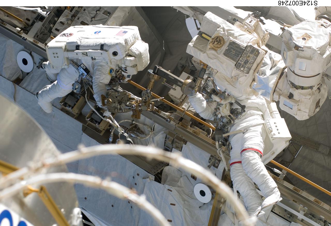 S124-E-007248 (8 June 2008) --- Astronauts Mike Fossum (right) and Ron Garan, both STS-124 mission specialists, participate in the mission's third scheduled session of extravehicular activity (EVA) as construction and maintenance continue on the International Space Station. During the six-hour, 33-minute spacewalk, Fossum and Garan exchanged a depleted Nitrogen Tank Assembly for a new one, removed thermal covers and launch locks from the Kibo laboratory, reinstalled a repaired television camera onto the space station's left P1 truss, and retrieved samples of a dust-like substance from the left Solar Alpha Rotary Joint for analysis by experts on the ground.