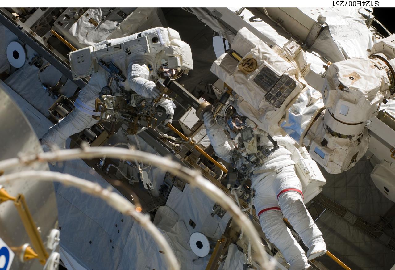 S124-E-007251 (8 June 2008) --- Astronauts Mike Fossum (right) and Ron Garan, both STS-124 mission specialists, participate in the mission's third scheduled session of extravehicular activity (EVA) as construction and maintenance continue on the International Space Station. During the six-hour, 33-minute spacewalk, Fossum and Garan exchanged a depleted Nitrogen Tank Assembly for a new one, removed thermal covers and launch locks from the Kibo laboratory, reinstalled a repaired television camera onto the space station's left P1 truss, and retrieved samples of a dust-like substance from the left Solar Alpha Rotary Joint for analysis by experts on the ground.