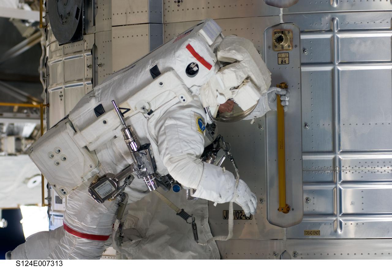 S124-E-007313 (8 June 2008) --- Astronaut Mike Fossum, STS-124 mission specialist, participates in the mission's third scheduled session of extravehicular activity (EVA) as construction and maintenance continue on the International Space Station. During the six-hour, 33-minute spacewalk, Fossum and astronaut Ron Garan (out of frame), mission specialist, exchanged a depleted Nitrogen Tank Assembly for a new one, removed thermal covers and launch locks from the Kibo laboratory, reinstalled a repaired television camera onto the space station's left P1 truss, and retrieved samples of a dust-like substance from the left Solar Alpha Rotary Joint for analysis by experts on the ground.