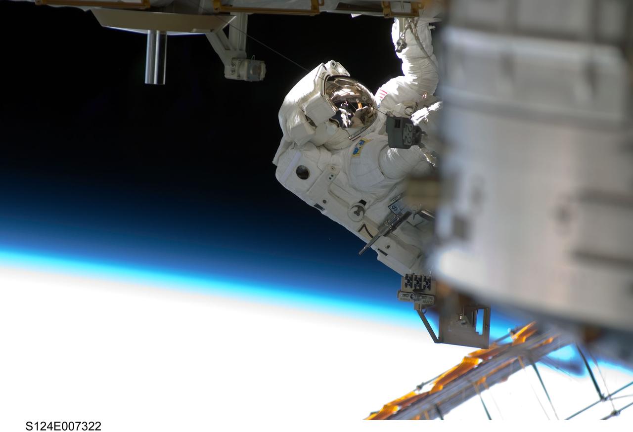 S124-E-007322 (8 June 2008) --- Astronaut Ron Garan, STS-124 mission specialist, participates in the mission's third scheduled session of extravehicular activity (EVA) as construction and maintenance continue on the International Space Station. During the six-hour, 33-minute spacewalk, Garan and astronaut Mike Fossum (out of frame), mission specialist, exchanged a depleted Nitrogen Tank Assembly for a new one, removed thermal covers and launch locks from the Kibo laboratory, reinstalled a repaired television camera onto the space station's left P1 truss, and retrieved samples of a dust-like substance from the left Solar Alpha Rotary Joint for analysis by experts on the ground. The blackness of space and Earth's atmosphere provide the backdrop for the scene.