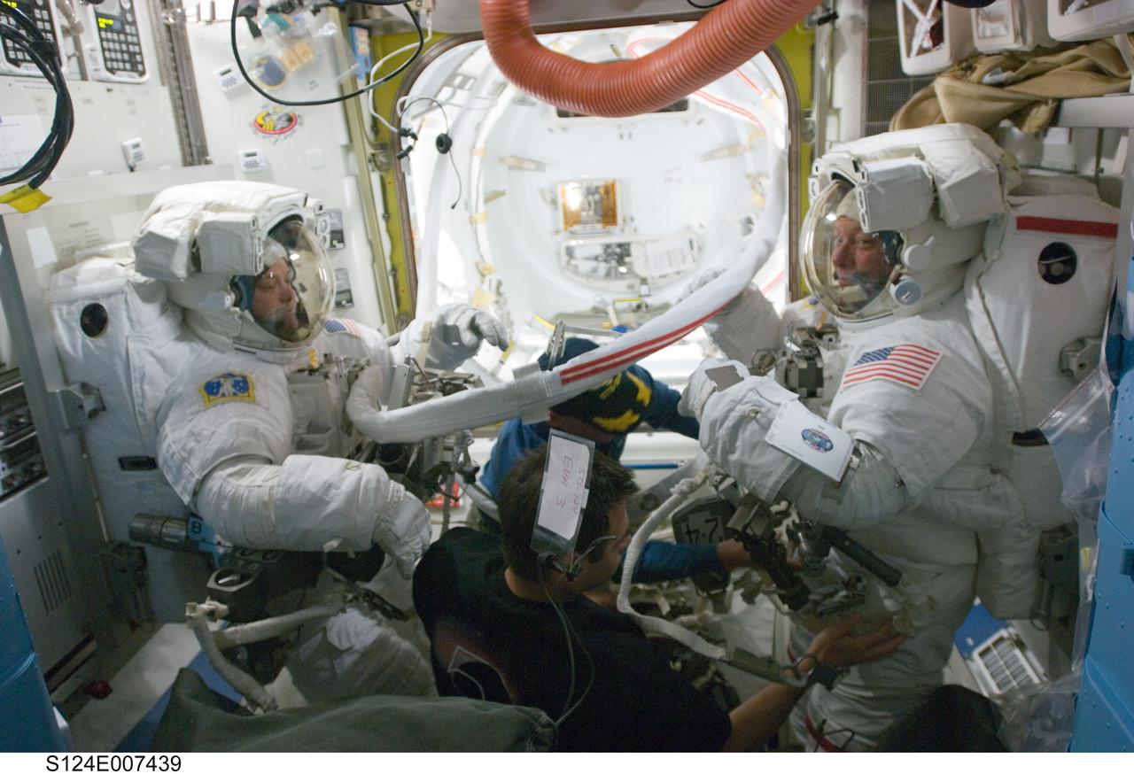 S124-E-007439 (8 June 2008) --- Astronauts Ron Garan (left) and Mike Fossum (right), both STS-124 mission specialists, prepare for the mission's third scheduled session of extravehicular activity (EVA) in the Quest Airlock of the International Space Station while Space Shuttle Discovery is docked with the station. Astronauts Mark Kelly (background center), commander, and Greg Chamitoff, Expedition 17 flight engineer, assisted Garan and Fossum.
