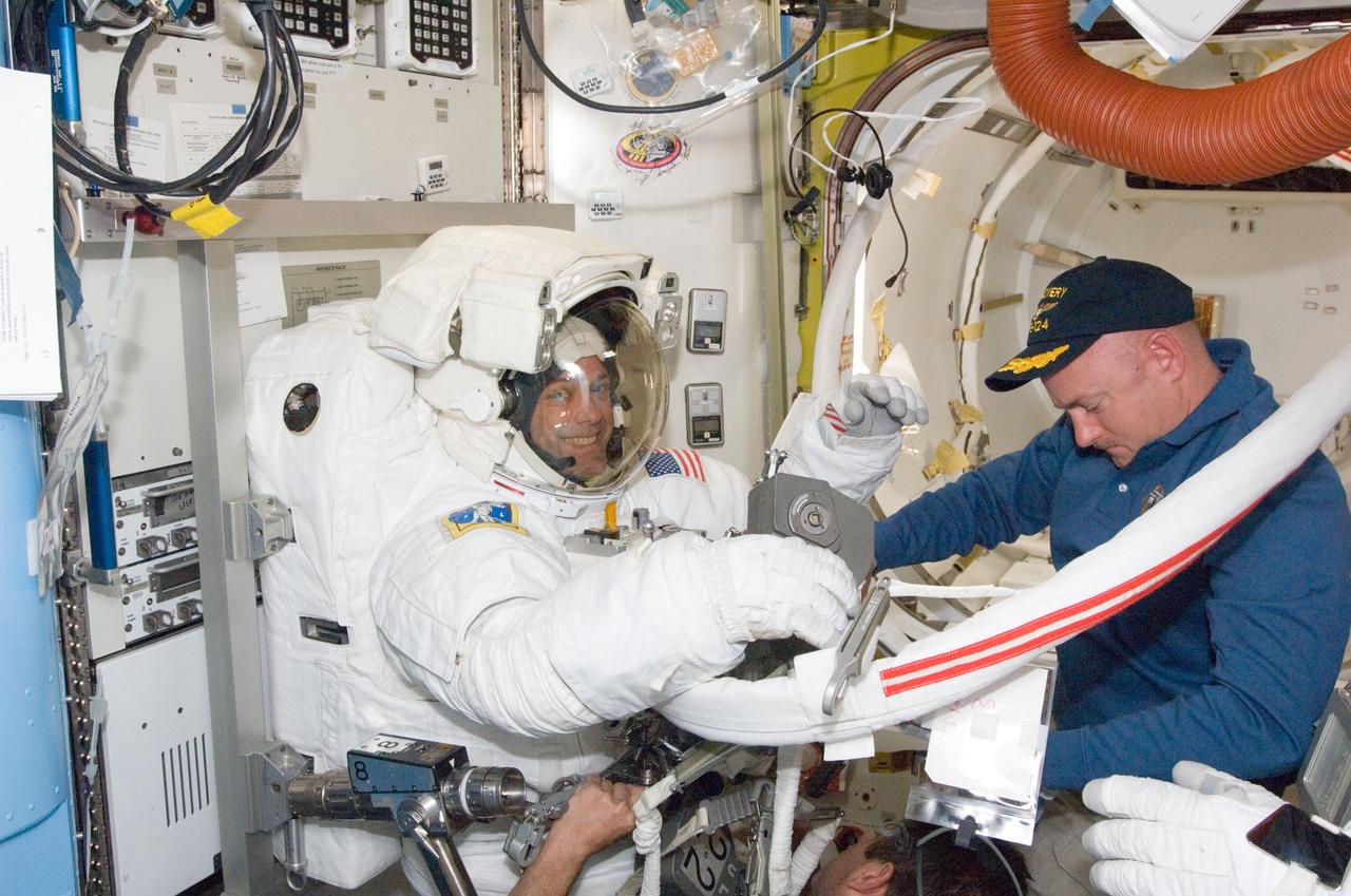 S124-E-007446 (8 June 2008) --- Astronaut Ron Garan, STS-124 mission specialist, prepares for the mission's third scheduled session of extravehicular activity (EVA) in the Quest Airlock of the International Space Station while Space Shuttle Discovery is docked with the station. Astronaut Mark Kelly, commander, assisted Garan.