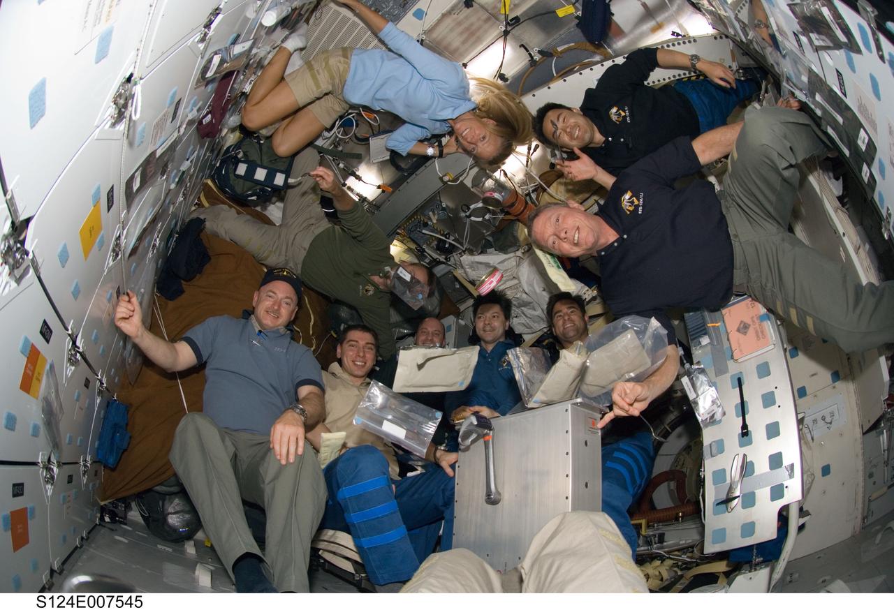 S124-E-007545 (8 June 2008) --- A "fish-eye" lens on a digital still camera was used to record this image of the STS-124 and Expedition 17 crewmembers as they share a meal on the middeck of the Space Shuttle Discovery while docked with the International Space Station. Pictured counter-clockwise (from the left bottom) are NASA astronauts Mark Kelly, STS-124 commander; Russian Federal Space Agency cosmonaut Sergei Volkov, Expedition 17 commander; NASA astronaut Garrett Reisman, STS-124 mission specialist; Russian Federal Space Agency cosmonaut Oleg Kononenko; NASA astronauts Greg Chamitoff, both Expedition 17 flight engineers; NASA astronaut Mike Fossum, Japan Aerospace Exploration Agency (JAXA) astronaut Akihiko Hoshide, NASA astronaut Karen Nyberg, all STS-124 mission specialists; and NASA astronaut Ken Ham, STS-124 pilot.