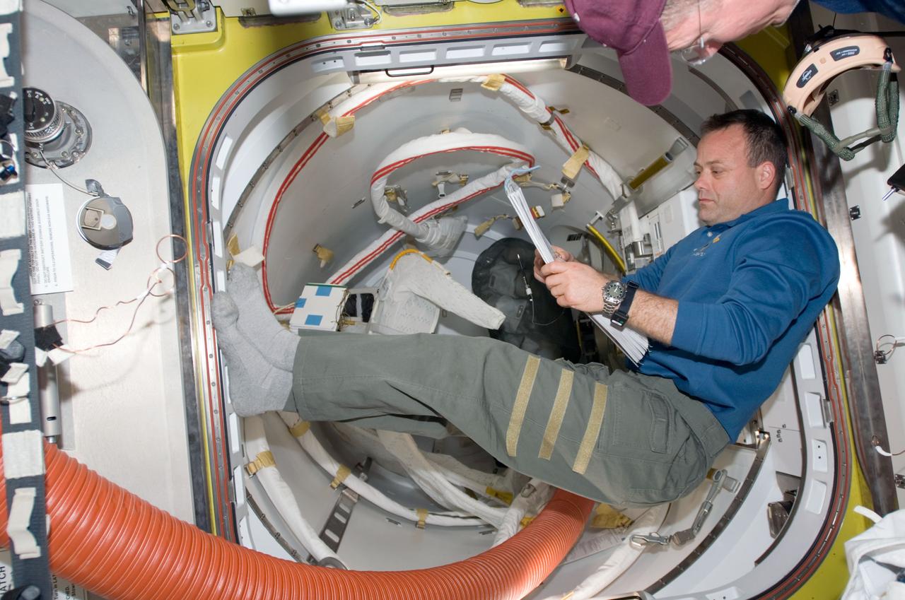 S124-E-007733 (7 June 2008) --- Astronaut Ron Garan, STS-124 mission specialist, goes over a checklist while preparing for the third and final session of extravehicular activity (EVA) scheduled for the following day. Astronauts Garan and Mike Fossum (out of frame) have already successfully completed two spacewalks to complete a variety of tasks.